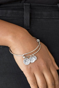Stamped in dandelion patterns, glistening silver charms featuring floral patterns slide along a sleek bar fitting for a whimsical look. Features a toggle closure.  Sold as one individual bracelet.
