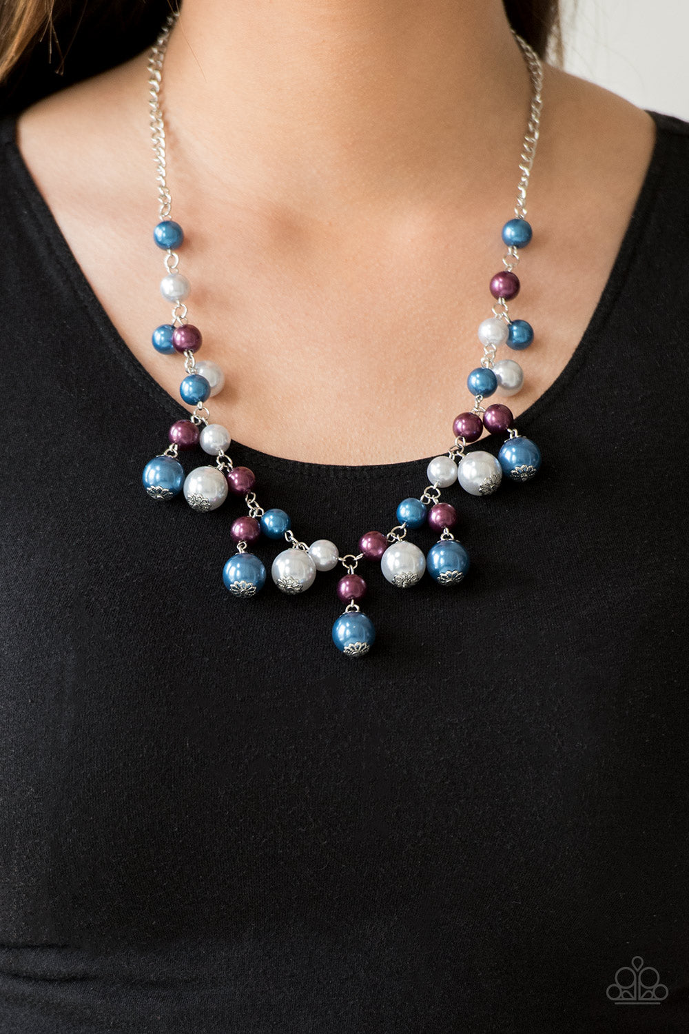Varying in size, bubbly blue, purple, and silver pearls swing from the bottom of a classic strand of pearls, creating a refined fringe below the collar. Features an adjustable clasp closure.  Sold as one individual necklace. Includes one pair of matching earrings.