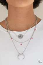 Load image into Gallery viewer, A silver floral frame swings from the uppermost chain, above a strand of faceted pink beads swinging from a shimmery silver chain. A silver crescent frame swings from the lowermost chain, creating whimsical layers down the chest. Features an adjustable clasp closure.  Sold as one individual necklace. Includes one pair of matching earrings.