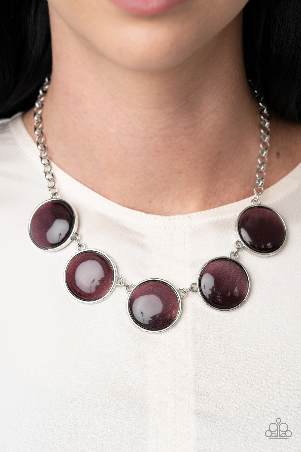 Featuring sleek silver fittings, a collection of round purple cat's eye stone pendants link below the collar for a colorfully ethereal look. Features an adjustable clasp closure.  Sold as one individual necklace. Includes one pair of matching earrings.