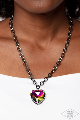 Flirtatiously Flashy - Multi Item #P2RE-MTXX-154XX Set atop a sleek gunmetal fitting, a glittery oil spill heart-shaped gem swings from the bottom of a classic gunmetal chain below the collar for a whimsical look. Features an adjustable clasp closure. Due to its prismatic palette, color may vary.  Sold as one individual necklace. Includes one pair of matching earrings.  New Kit ENCORE