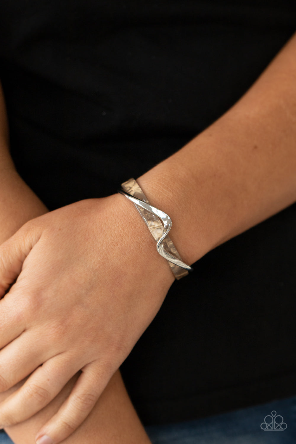 A flat silver bar delicately curls across a dainty brown shell-like acrylic cuff, creating a whimsical centerpiece around the wrist.  Sold as one individual bracelet.