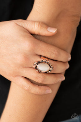A glowing cat's eye stone is pressed into the center of an ornately studded copper frame, creating a mystical pop of color atop the finger. Features a stretchy band for a flexible fit.  Sold as one individual ring.
