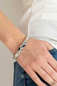 A jumble of dazzling blue and white rectangle-shaped rhinestones mingle with small blue sparkling rhinestones atop a modern stamped silver cuff.  Sold as one individual bracelet.