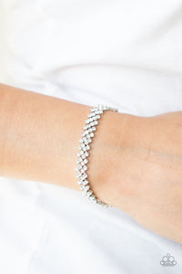Featuring sleek silver fittings, dainty rows of glassy white rhinestones delicately slant across the wrist, coalescing into a timeless centerpiece. Features an adjustable clasp closure.  Sold as one individual bracelet.