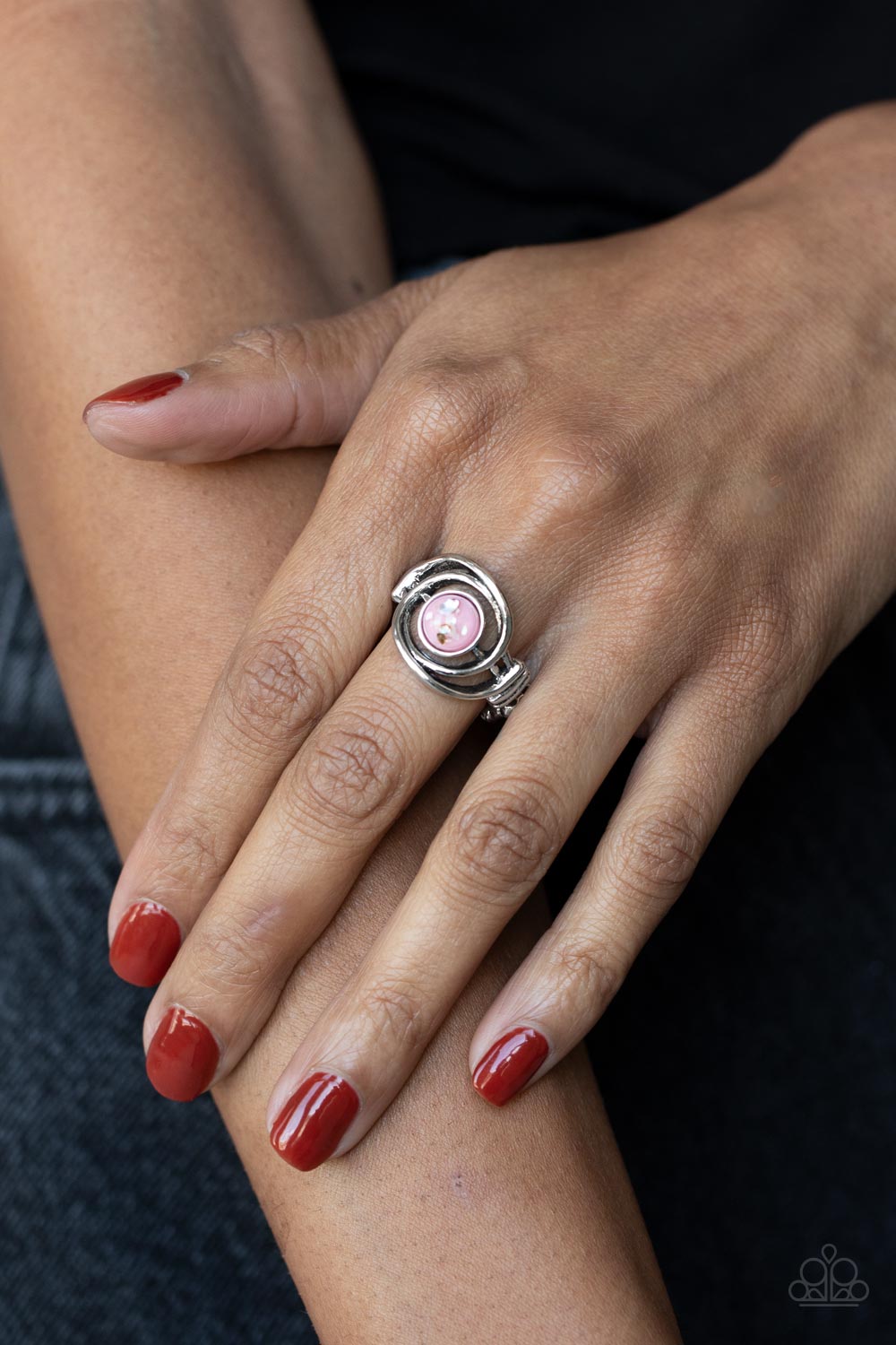 Glistening silver bars swirl around a glassy pink bead flecked in iridescent shell, creating an ethereal centerpiece atop the finger. Features a dainty stretchy band atop the finger.  Sold as one individual ring.