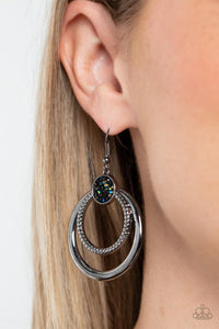Smooth and textured silver hoops connect to the bottom of a silver fitting embellished in glitzy oil spill and hematite rhinestones, creating a dizzying lure. Earring attaches to a standard fishhook fitting.  Sold as one pair of earrings.
