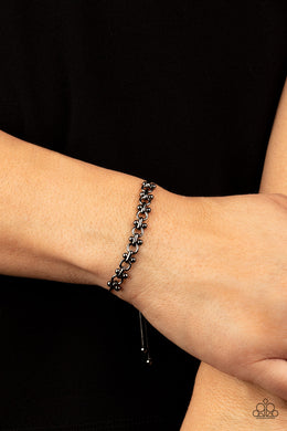 A dainty section of gunmetal beaded fittings and gunmetal links delicately attaches to a rounded gunmetal snake chain around the wrist, creating a sleek metallic shimmer. Features an adjustable sliding bead closure.  Sold as one individual bracelet.