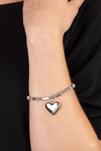 Load image into Gallery viewer, Encased in sleek silver fittings, round and emerald cut rhinestones delicately link into a sparkly chain around the wrist. A shiny silver heart charm swings from the glittery compilation, adding a flirtatious shimmer. Features an adjustable clasp closure.  Sold as one individual bracelet.