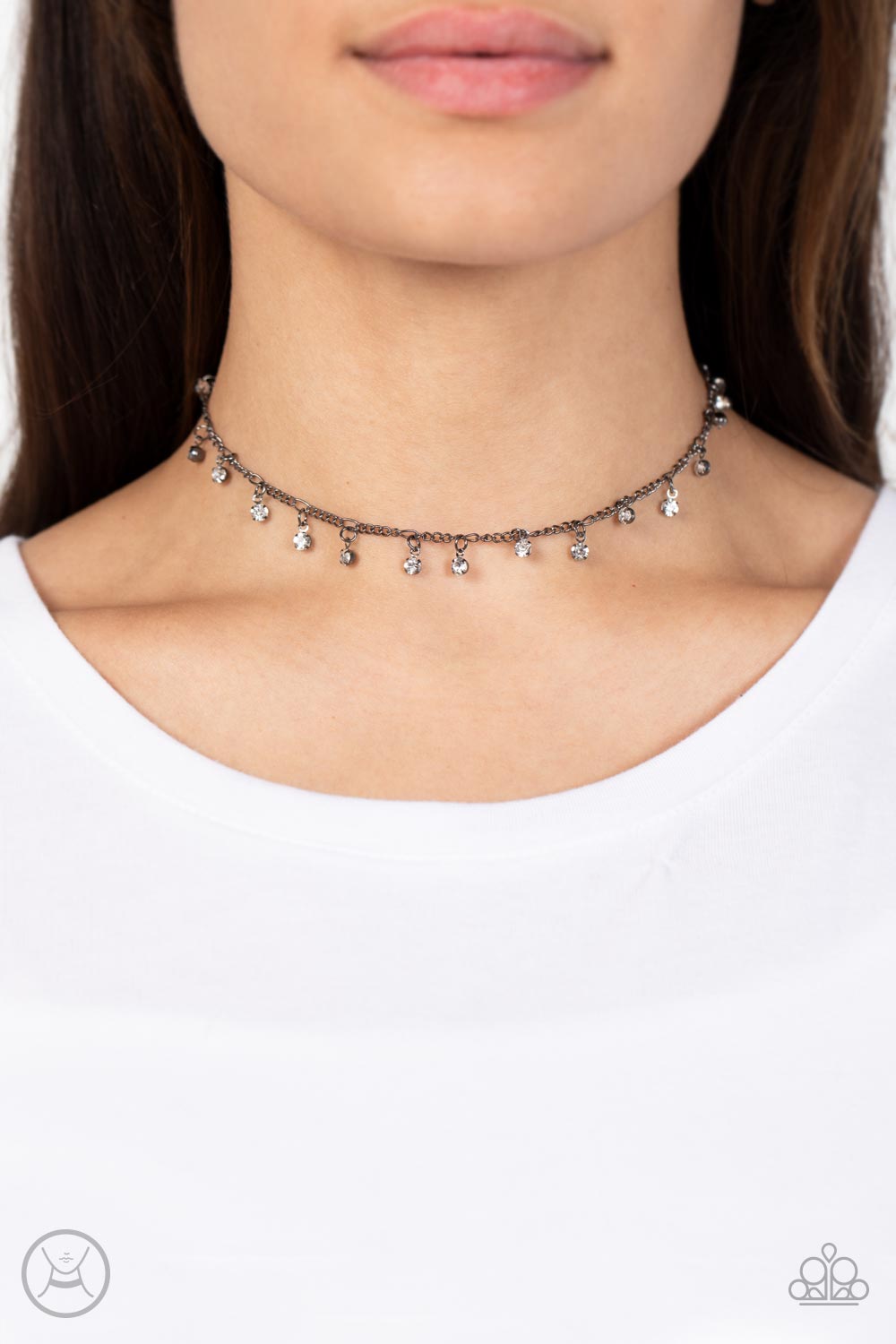 Encased in gritty gunmetal fittings, glassy white rhinestones dance from the bottom of a dainty gunmetal chain for a dash of spell-binding radiance around the neck.  Sold as one individual choker necklace. Includes one pair of matching earrings.