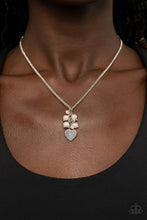 Load image into Gallery viewer, Dotted with a dainty iridescent rhinestone, a shiny silver heart swings from the bottom of a bubbly cluster of white pearls and iridescent rhinestones, creating a locket inspired pendant below the collar. Features an adjustable clasp closure.  Sold as one individual necklace. Includes one pair of matching earrings.
