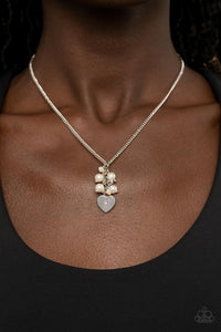 Dotted with a dainty iridescent rhinestone, a shiny silver heart swings from the bottom of a bubbly cluster of white pearls and iridescent rhinestones, creating a locket inspired pendant below the collar. Features an adjustable clasp closure.  Sold as one individual necklace. Includes one pair of matching earrings.