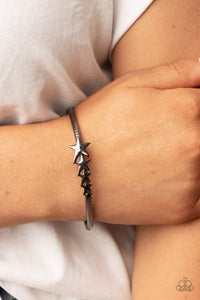 Glistening gunmetal stars graduate in size across the center of a textured gunmetal bangle, creating a stackable stellar centerpiece around the wrist.  Sold as one individual bracelet.