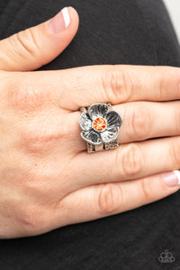 Textured silver petals gently gather around a sparkling orange rhinestone center, blooming into a dazzling floral centerpiece atop the finger. Features a stretchy band for a flexible fit.  Sold as one individual ring.