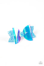 Load image into Gallery viewer, An iridescent plastic bow is layered over a glittery blue fabric cutout creating a shimmering futuristic vibe. Features a standard hair clip on the back.  Sold as one individual hair clip.